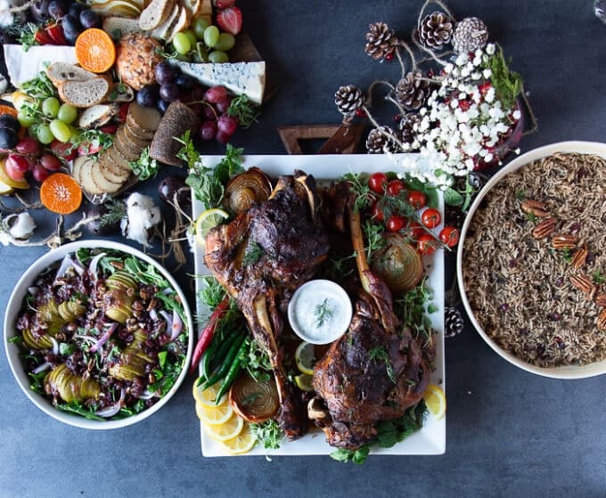 A whole meat with roast leg of lamb, some side dishes of rice, salad and a cheese platter