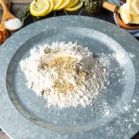 A large shallow plate of flour with seasoning added on top