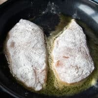 floured chicken breasts are added to heavy skillet with butter without over crowding and waiting to golden sear on each side