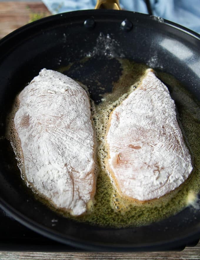 floured chicken breasts are added to heavy skillet with butter without over crowding and waiting to golden sear on each side