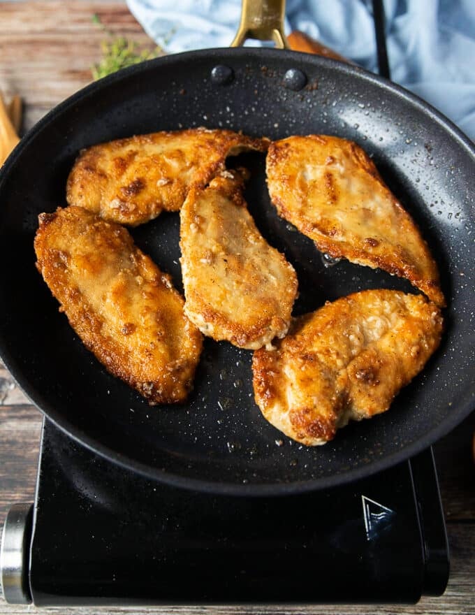 perfectly golden brown cicken breasts pan seared on each side for the chicken scallopini recipe