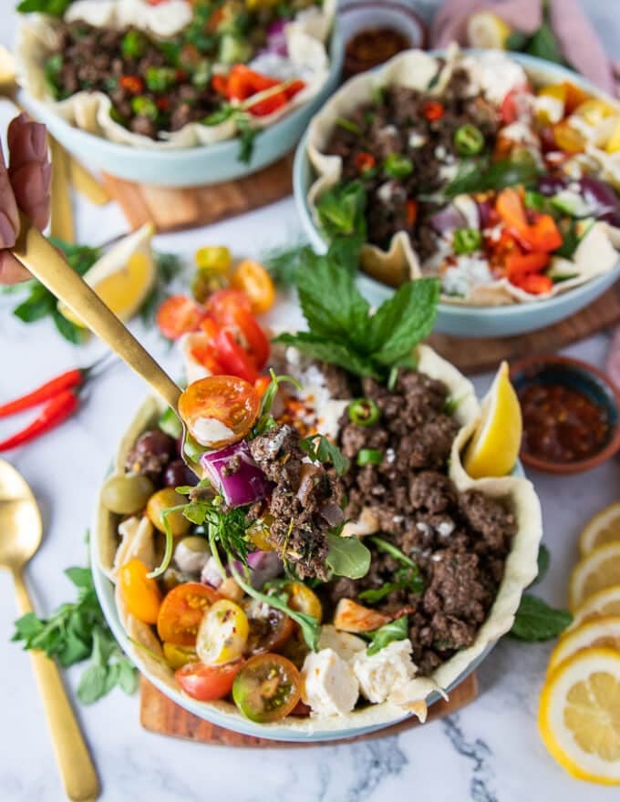 A fork showing a spoonful of pita bowl ingredients grabbed from the pita bowl to be enjoyed right away