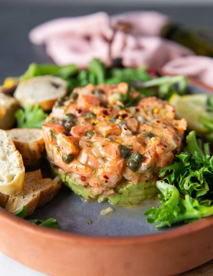 Side view of the salmon tartare recipe showing the beautiful layers of avocado and salmon stacked up into a delicious and gorgeous looking dish