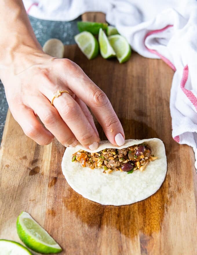 A hand placing the filling along the middle of the tortilla