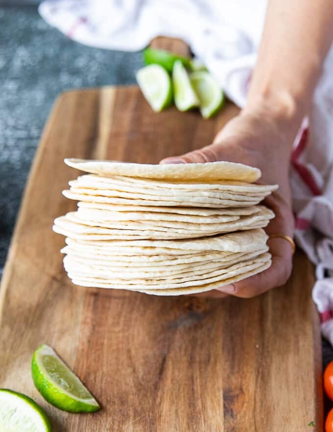 A hand holding the tortillas showing close up of the tortillas size and thickness