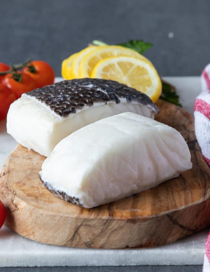 Chilean sea bass fillets on a wooden board showing the fillets 