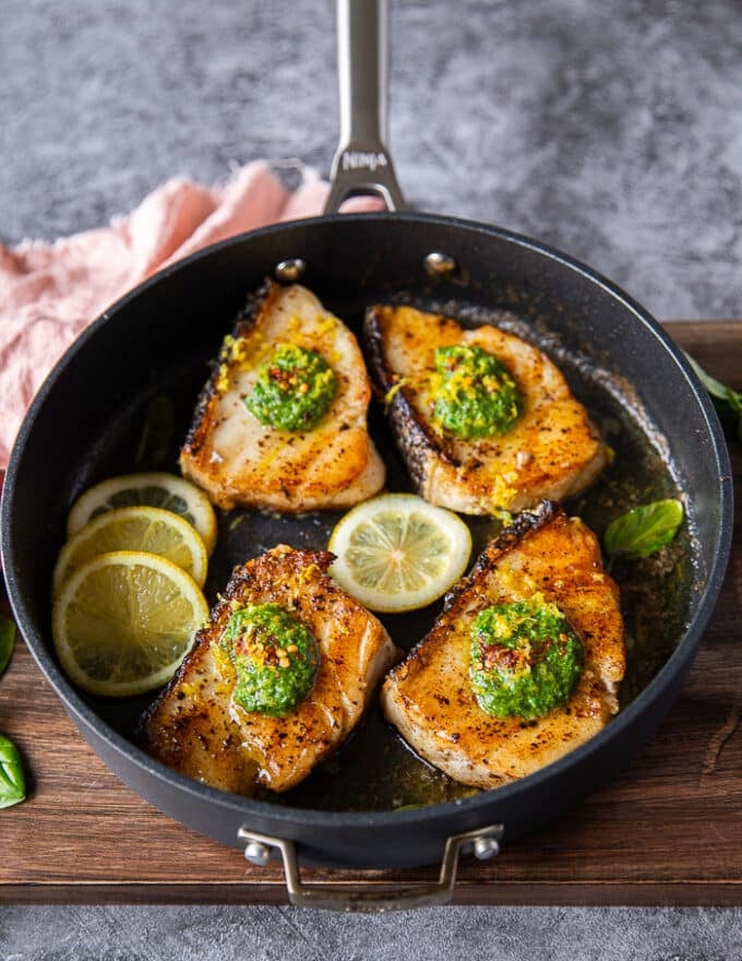 cooked Chilean sea bass in a pan finished off with more butter and lemon