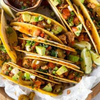 Close up of each assembled ground chicken taco showing different toppings for each one