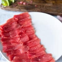 All the thinly sliced tuna is arranged neatly on the serving plate leaving room for some greens