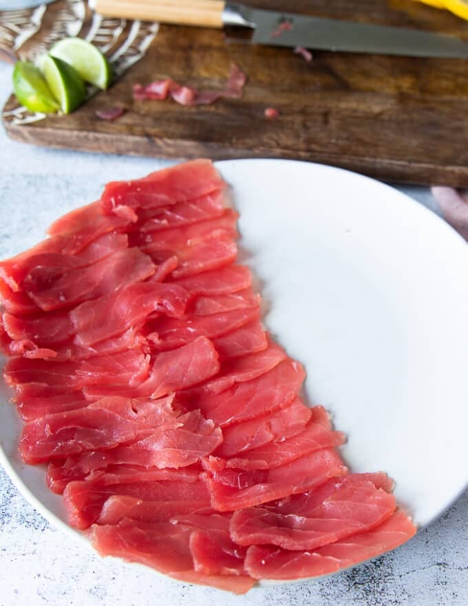 All the thinly sliced tuna is arranged neatly on the serving plate leaving room for some greens