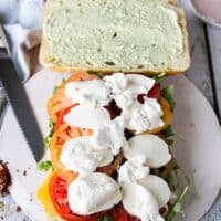 Fresh mozzarella slices and burrata go on top of the tomatoes for the caprese sandwich