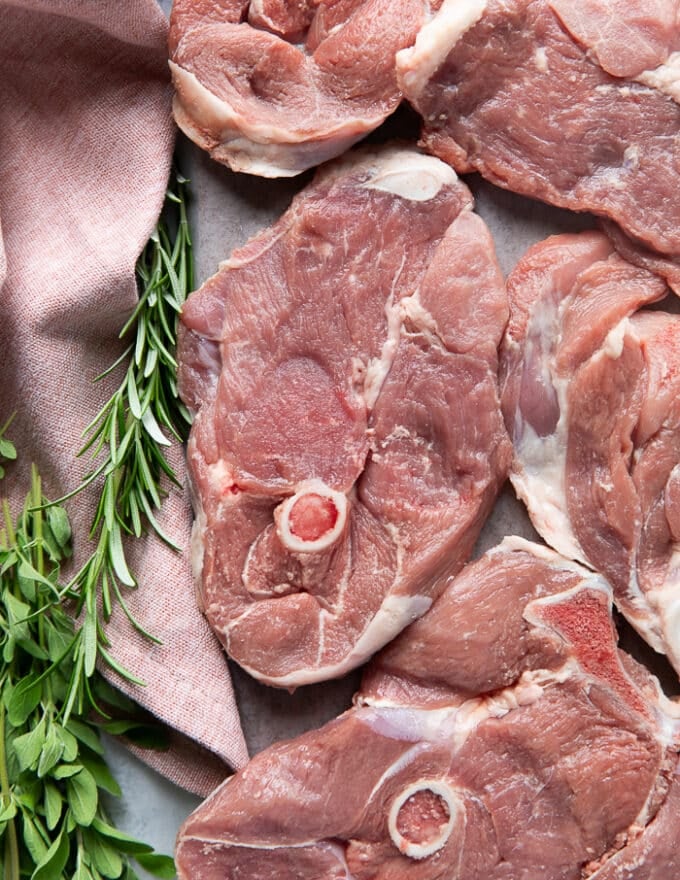 close up of a lamb steak showing the meat and bone in the center of the leg of lamb cut cross sectional
