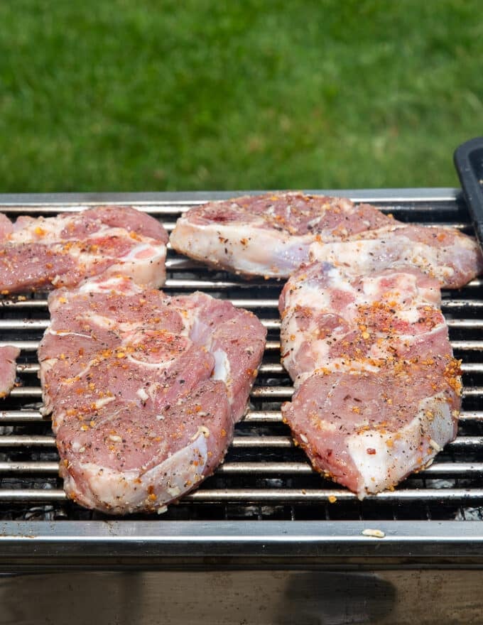 lamb steaks placed on a charcoal grill