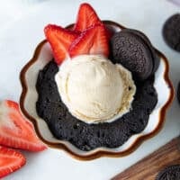 A perfectly made oreo mug cake served with ice cream, oreo cookies, strawberries ready to be served