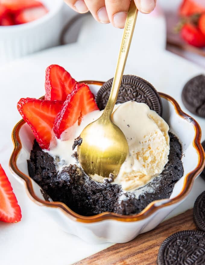 A mug cake scooped out showing the inside of the cake how gooey and cakey it is in the mug