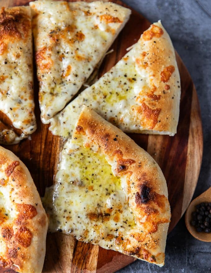 Cut up slices of the pizza on a wooden board