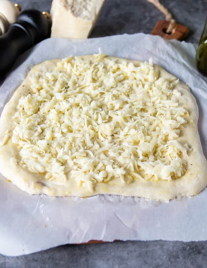 A thin layer of mozzarella cheese is added over the dough to make the pizza extra cheesy--optional 