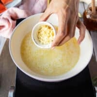 making the honey glaze showing a skillet of butter melting and garlic being added