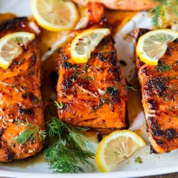 close up of a honey baked salmon showing the deep golden crust and sweet glaze over the salmon