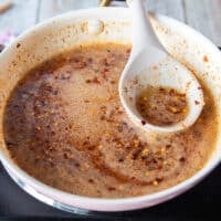 Honey and chili flakes in the sauce pan simmering on the edges and not boiling