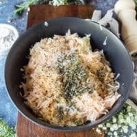 The remanning ingredients are added to the potato bowl such as flour, herbs and seasoning