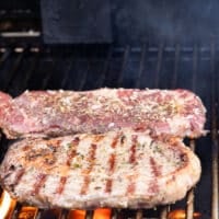 Flipped ribeye steak on the grill showing the grill marks