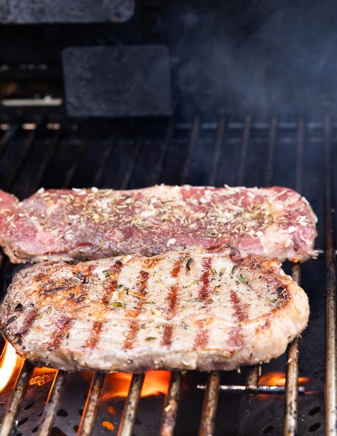 Flipped ribeye steak on the grill showing the grill marks