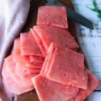 Finished slices of a block of watermelon on a wooden board