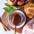 A spoon scooping apple butter from the jar showing close up of the thick and smooth texture