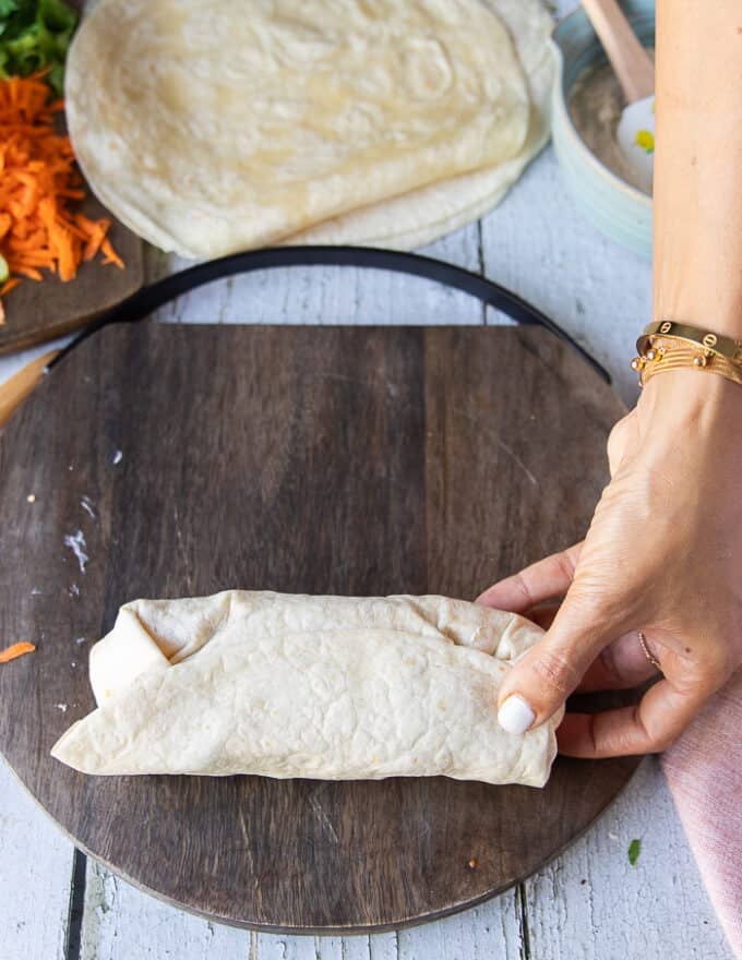 A hand holding the wrap on the other side showing how the seem looks sealed. 