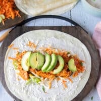 The final layer of the buffalo chicken wrap is the sliced avocados.