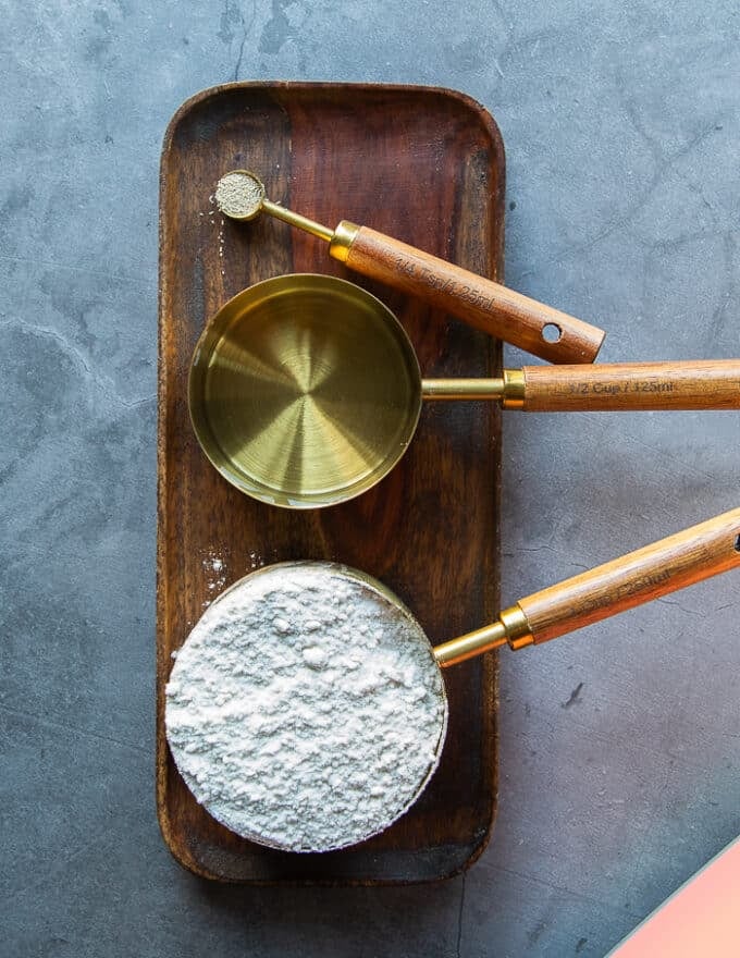 Starter ingredients including a bowl of water, bowl of flour and a small bit of yeast.