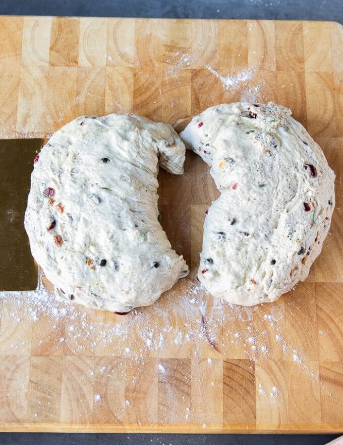 Fougasse dough divided into two halves on a wooden board