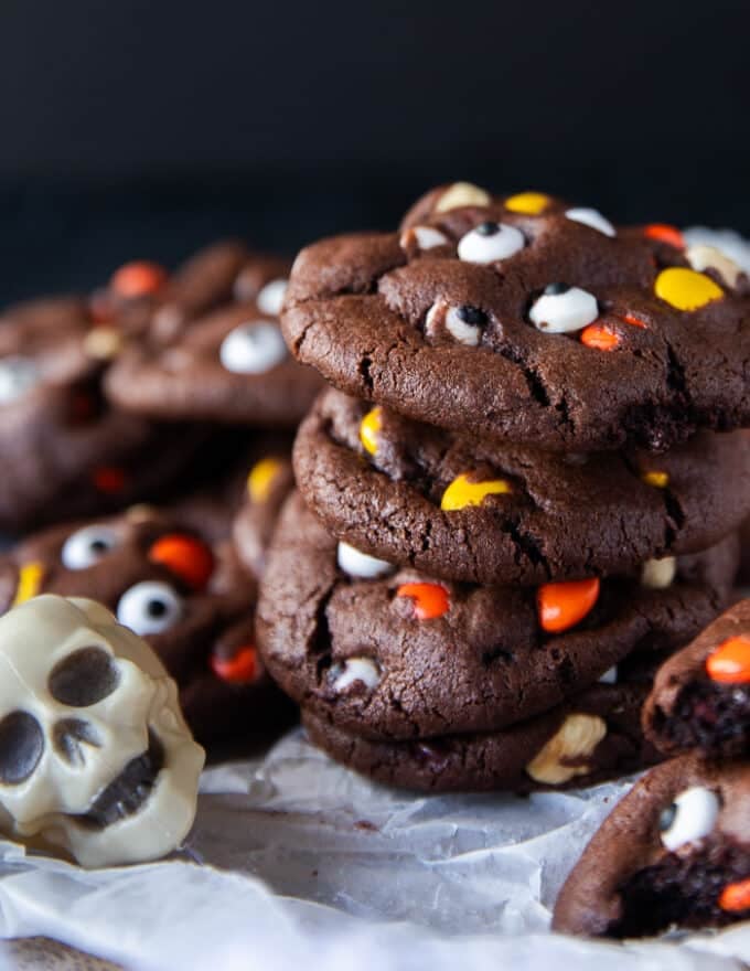 A stack of cookies on a white board surrounded by skulls for a spooky vibe