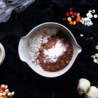 Dry ingredients added to a bowl including flour, cocoa powder, salt and baking soda