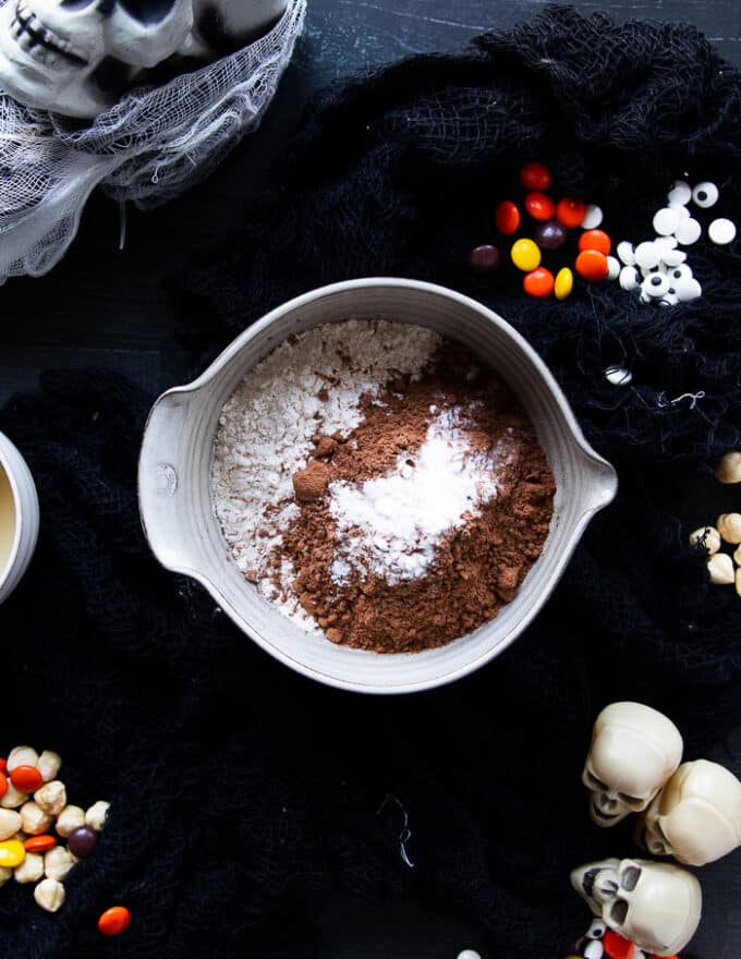 Dry ingredients added to a bowl including flour, cocoa powder, salt and baking soda