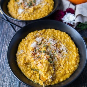 A plate of pumpkin risotto with a fork swirling it to show the texture of the risotto