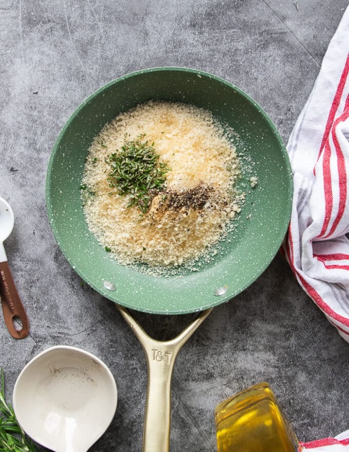 A small skillet with panko, herbs, garlic, olive oil and seasoning all added in