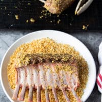 Rack of lamb dipped into a bowl of toasted breadcrumbs