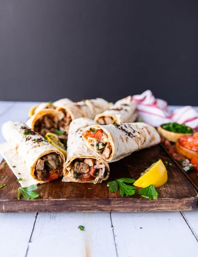 A wooden board with cut up tantuni ready to eat