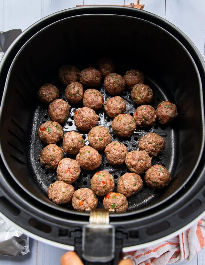 The meatballs are added into an air fryer basket