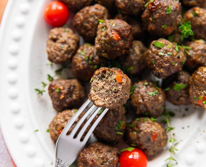 Air fryer Meatballs on a fork bitten and showing how perfectly cooked and juicy the meatballs are