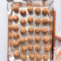 scooped up meatballs shaped into perfect meatball shape on a sheet pan