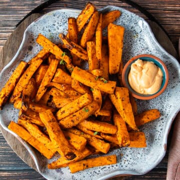 A plate with air fryer sweet potato fries and a dip on the side