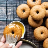 a hand brushing the donut with melted butter