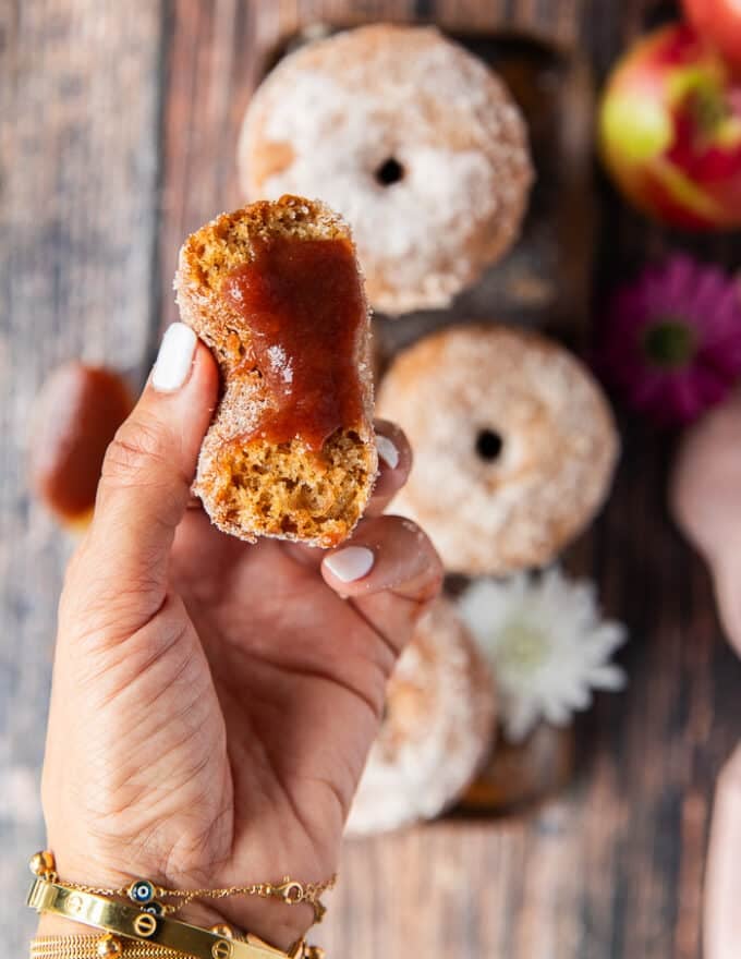 a hand holding a the apple cider donut spread with apple butter close up