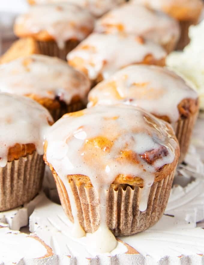 close up of a glazed banana bread muffin with the glaze dripping on the side