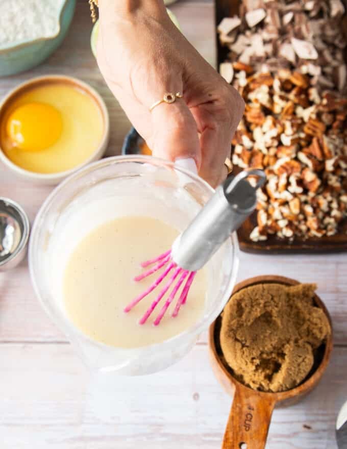 A hand holding some cream cheese glaze ready ahead of time.