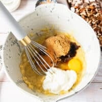 Wet ingredients added to the large bowl including egg, vanilla, yogurt, and oil