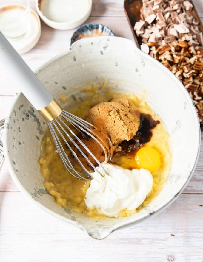 Wet ingredients added to the large bowl including egg, vanilla, yogurt, and oil